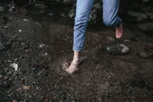 Woman walking barefoot in stream